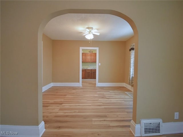 empty room featuring light wood-type flooring and ceiling fan