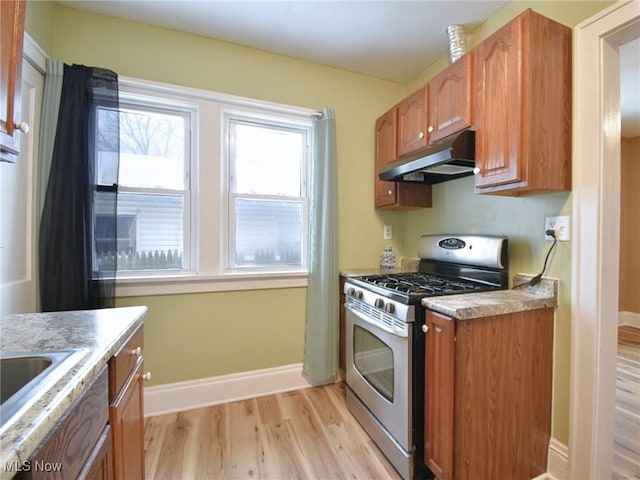 kitchen featuring light wood-type flooring, gas stove, and sink