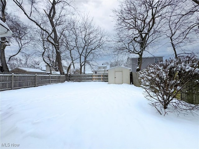 yard layered in snow with a storage shed