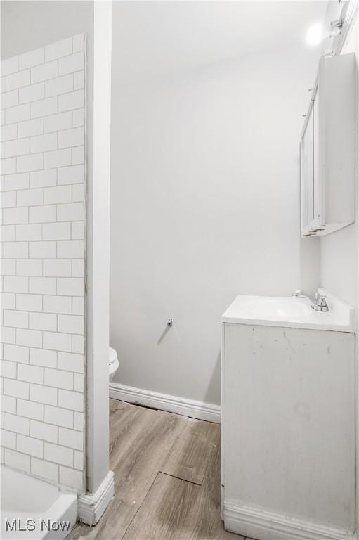 full bathroom with independent shower and bath, sink, wood-type flooring, and toilet