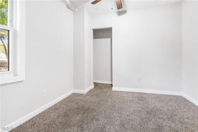 carpeted spare room featuring ceiling fan