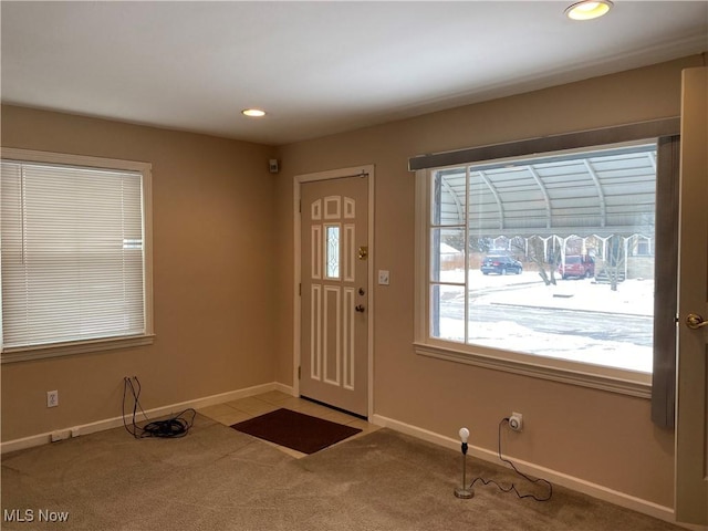 entrance foyer featuring a healthy amount of sunlight and light carpet