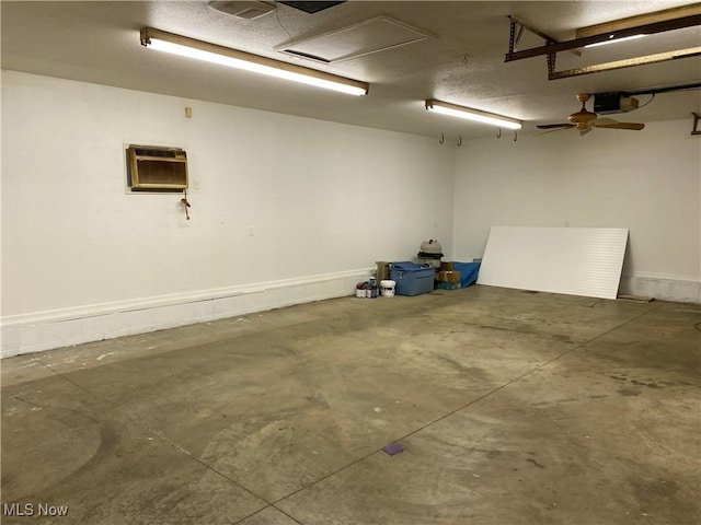 garage with a garage door opener, an AC wall unit, and ceiling fan