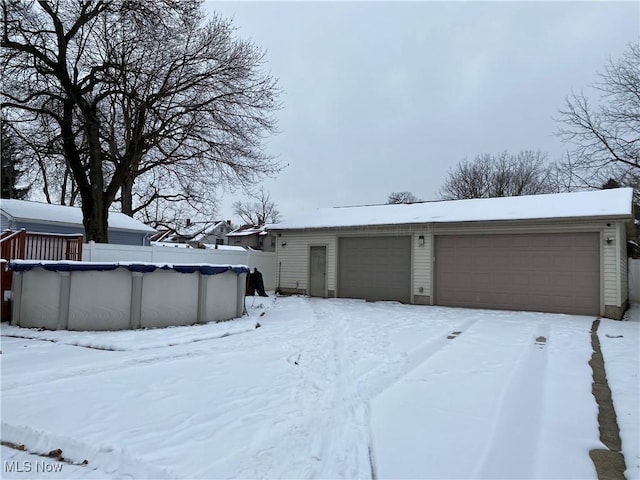 exterior space with a garage and a covered pool