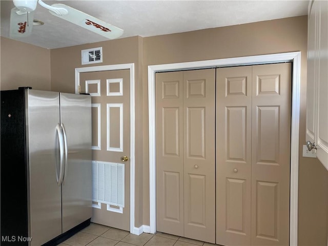 kitchen with stainless steel fridge and light tile patterned flooring