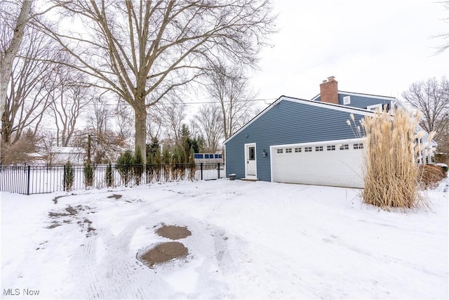 view of snow covered exterior featuring a garage