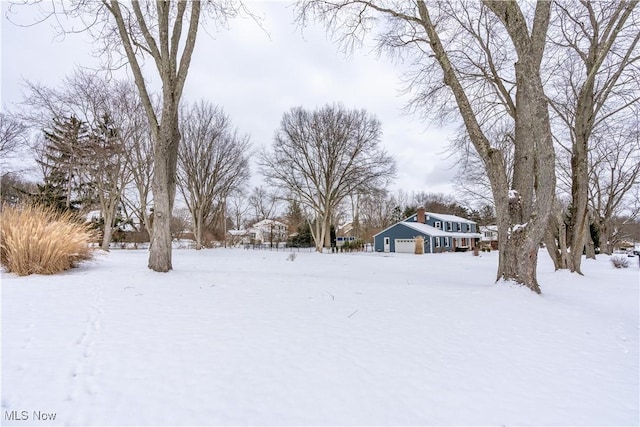 snowy yard featuring a garage