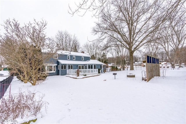 view of snow covered back of property