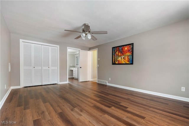 unfurnished bedroom with ceiling fan, dark hardwood / wood-style floors, and a closet