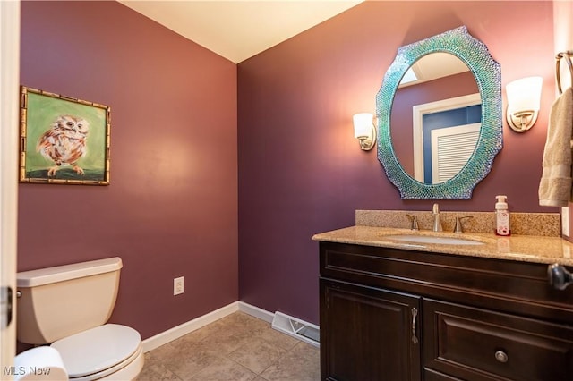 bathroom featuring tile patterned flooring, vanity, and toilet