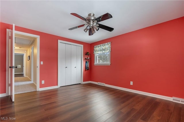 unfurnished bedroom with ceiling fan, a closet, and dark hardwood / wood-style floors