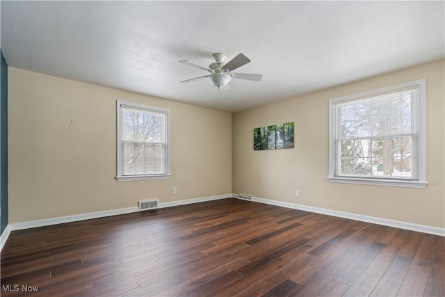 empty room with dark hardwood / wood-style flooring and ceiling fan