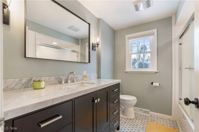 bathroom featuring vanity, toilet, and an enclosed shower