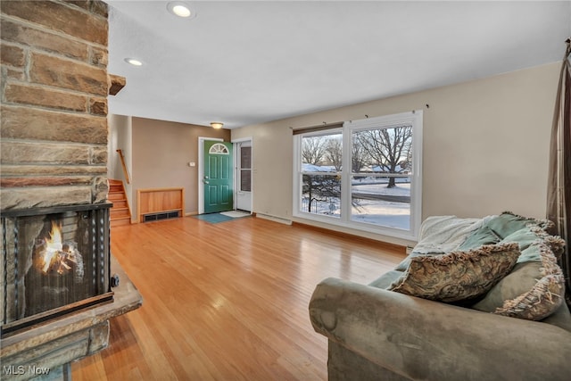 living room with wood-type flooring and a large fireplace