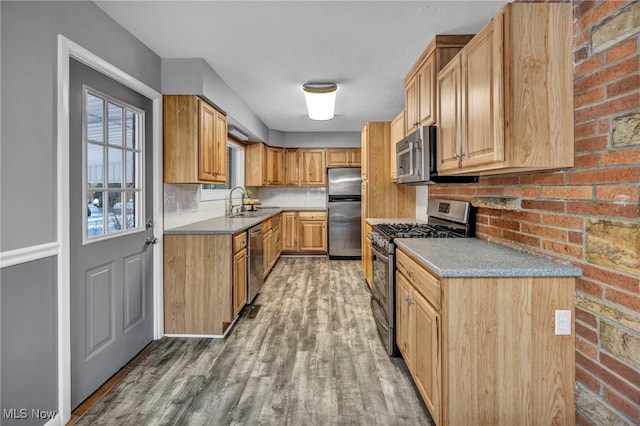 kitchen featuring light brown cabinets, sink, hardwood / wood-style flooring, decorative backsplash, and appliances with stainless steel finishes