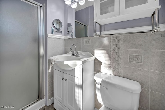 bathroom featuring tile walls, vanity, an enclosed shower, and toilet