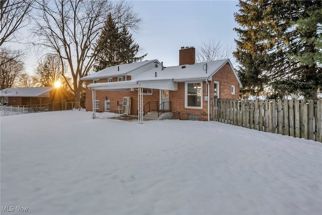 view of snow covered rear of property