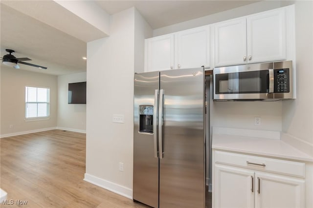 kitchen featuring white cabinets, appliances with stainless steel finishes, light hardwood / wood-style flooring, and ceiling fan