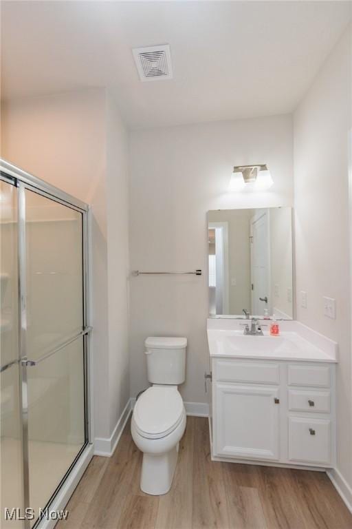 bathroom with vanity, wood-type flooring, an enclosed shower, and toilet