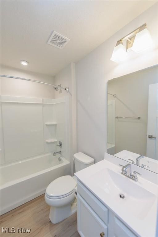 full bathroom featuring vanity, toilet, wood-type flooring, and bathing tub / shower combination