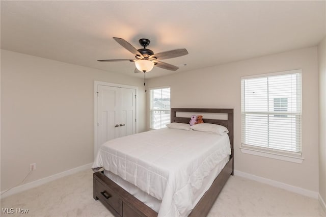 carpeted bedroom featuring a closet and ceiling fan