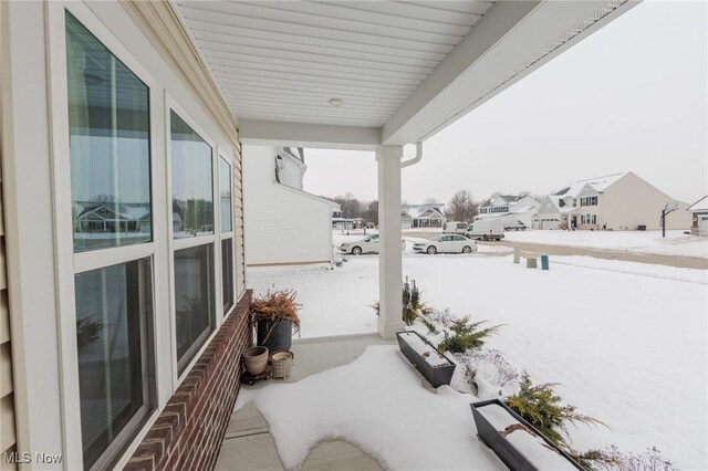 view of snow covered back of property