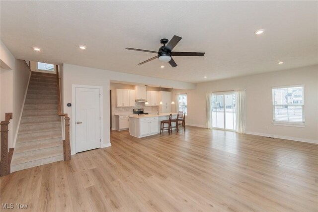 unfurnished living room with ceiling fan and light wood-type flooring