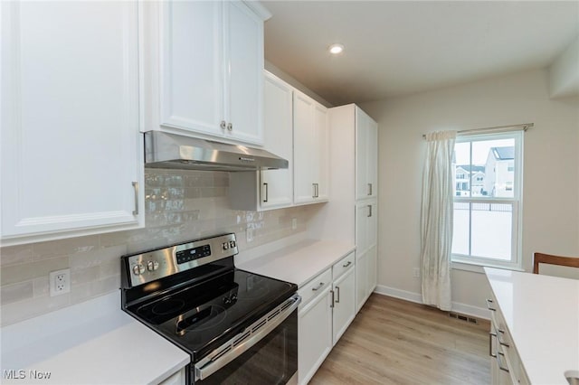 kitchen featuring light hardwood / wood-style floors, decorative backsplash, white cabinetry, and stainless steel electric range oven