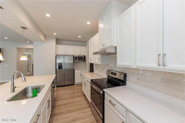 kitchen featuring sink, decorative backsplash, appliances with stainless steel finishes, decorative light fixtures, and white cabinetry