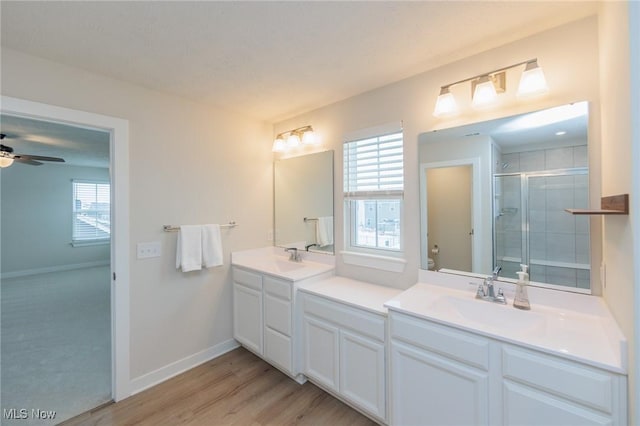 bathroom featuring vanity, an enclosed shower, wood-type flooring, and a wealth of natural light