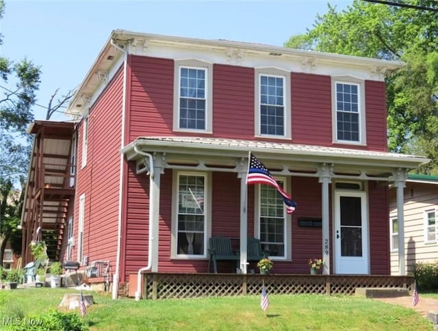 italianate home with covered porch and a front yard