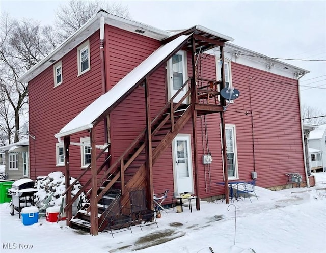 view of snow covered rear of property