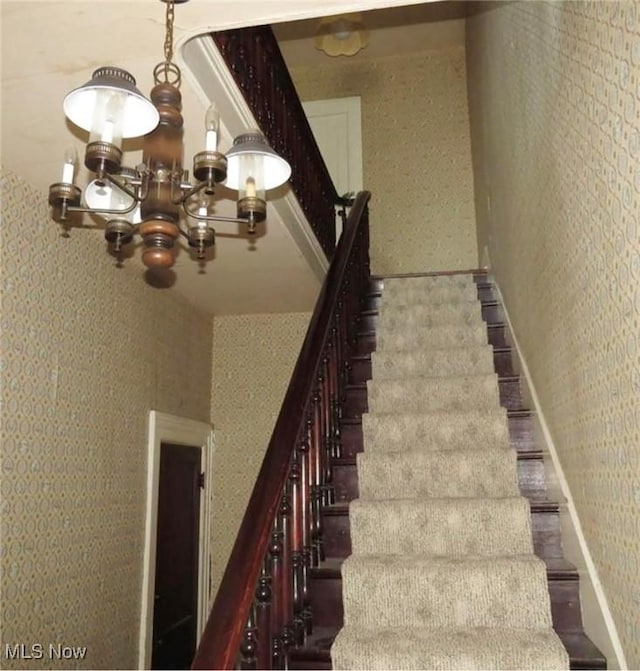 stairway featuring an inviting chandelier