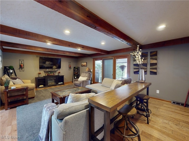 living room featuring beam ceiling and light wood-type flooring