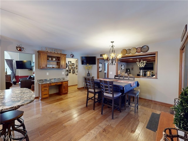 dining room with light wood-type flooring and an inviting chandelier