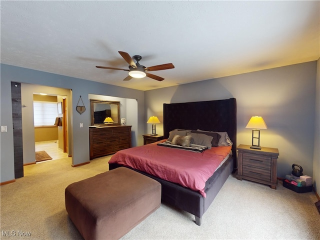 bedroom with connected bathroom, ceiling fan, and light colored carpet