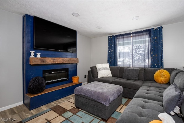 living room featuring a textured ceiling, wood-type flooring, and a fireplace