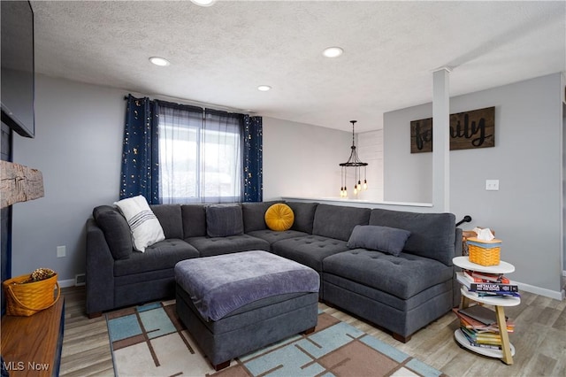 living room with light wood-type flooring and a textured ceiling