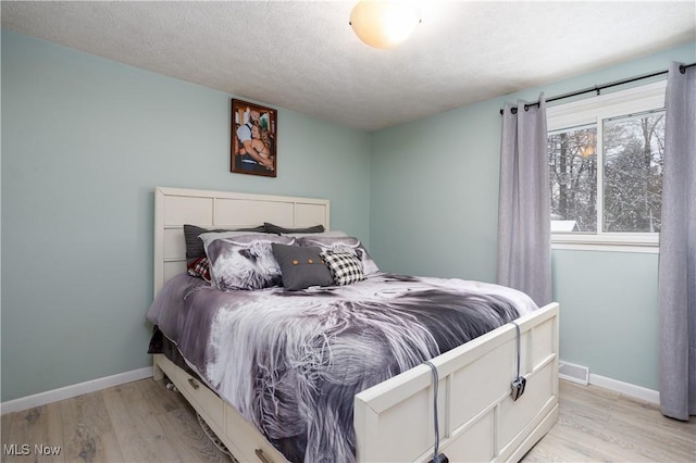 bedroom featuring a textured ceiling and light wood-type flooring