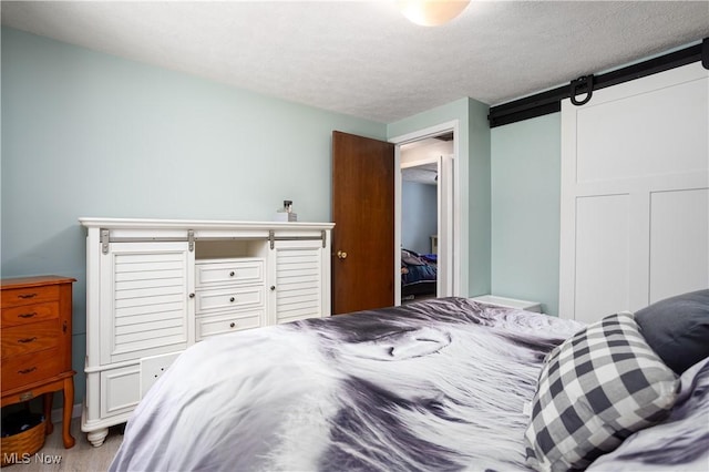 bedroom featuring hardwood / wood-style floors, a textured ceiling, and a closet