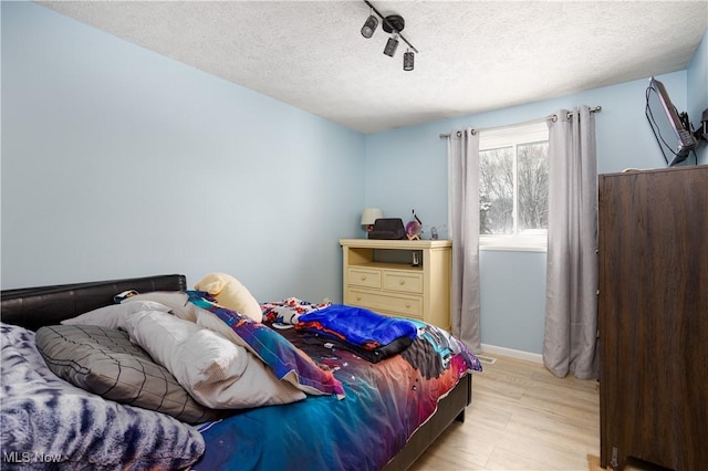 bedroom featuring a textured ceiling and light hardwood / wood-style floors