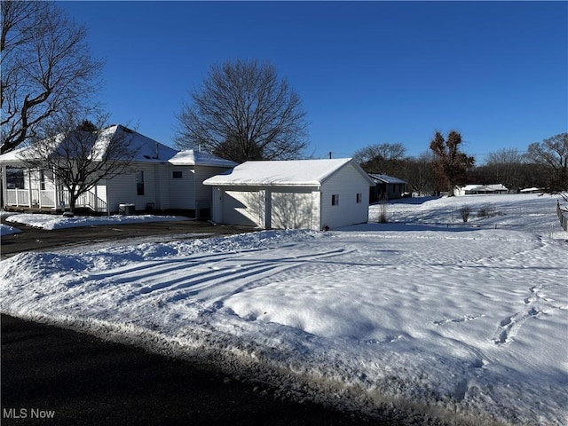 exterior space with an outdoor structure, a garage, and central air condition unit