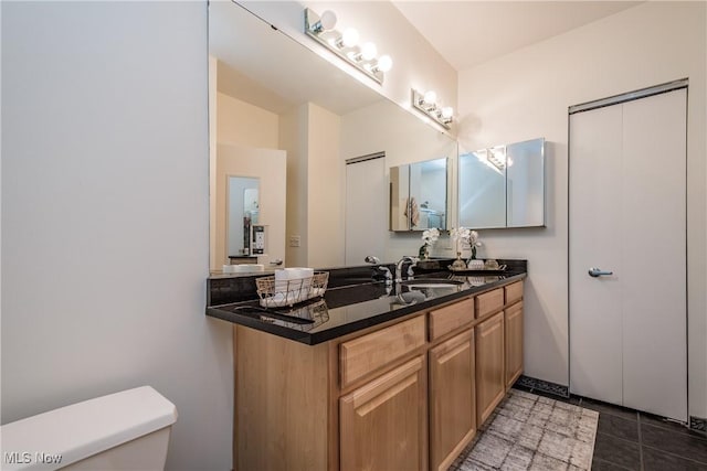 bathroom featuring toilet, tile patterned flooring, and vanity