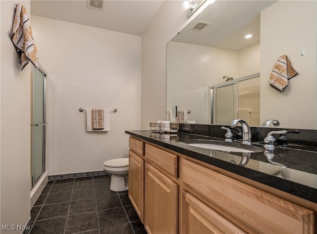 bathroom featuring vanity, a shower with shower door, and toilet