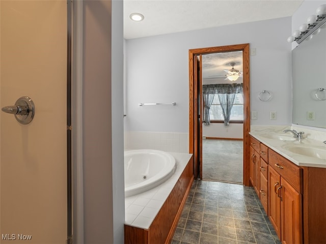 bathroom featuring tiled bath, vanity, and ceiling fan