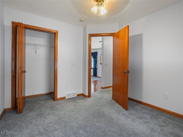 unfurnished bedroom with ceiling fan, a closet, and carpet