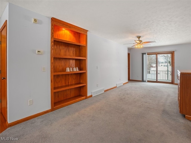 unfurnished living room with ceiling fan, light carpet, and a textured ceiling