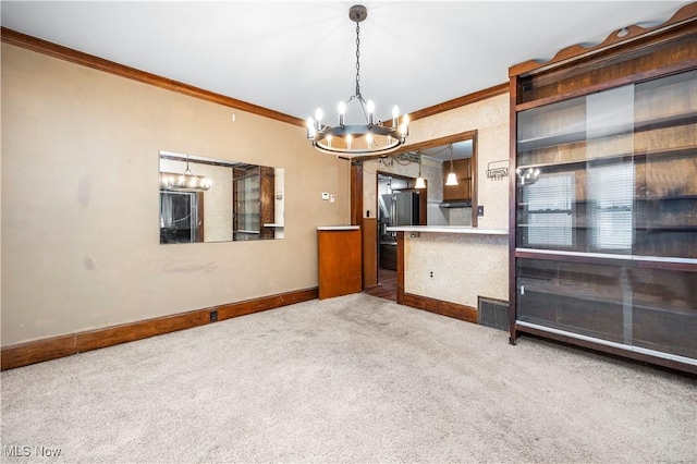 carpeted spare room featuring a chandelier and ornamental molding