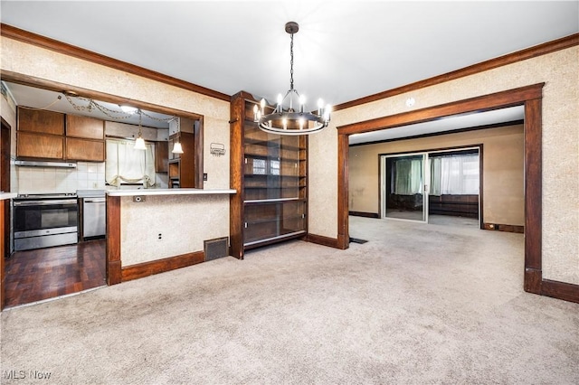 kitchen featuring stainless steel appliances, tasteful backsplash, crown molding, pendant lighting, and light carpet