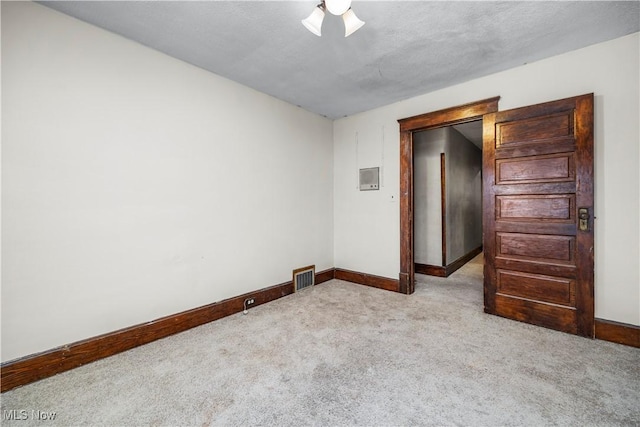 carpeted spare room featuring a textured ceiling